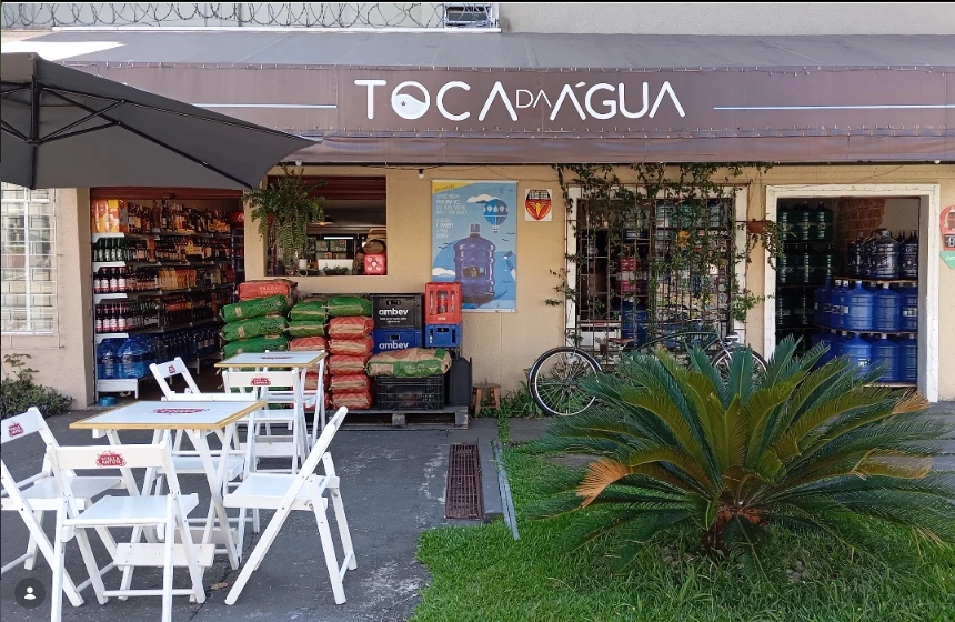 Fachada da loja Toca da Água com mesas, estoque de água e gás